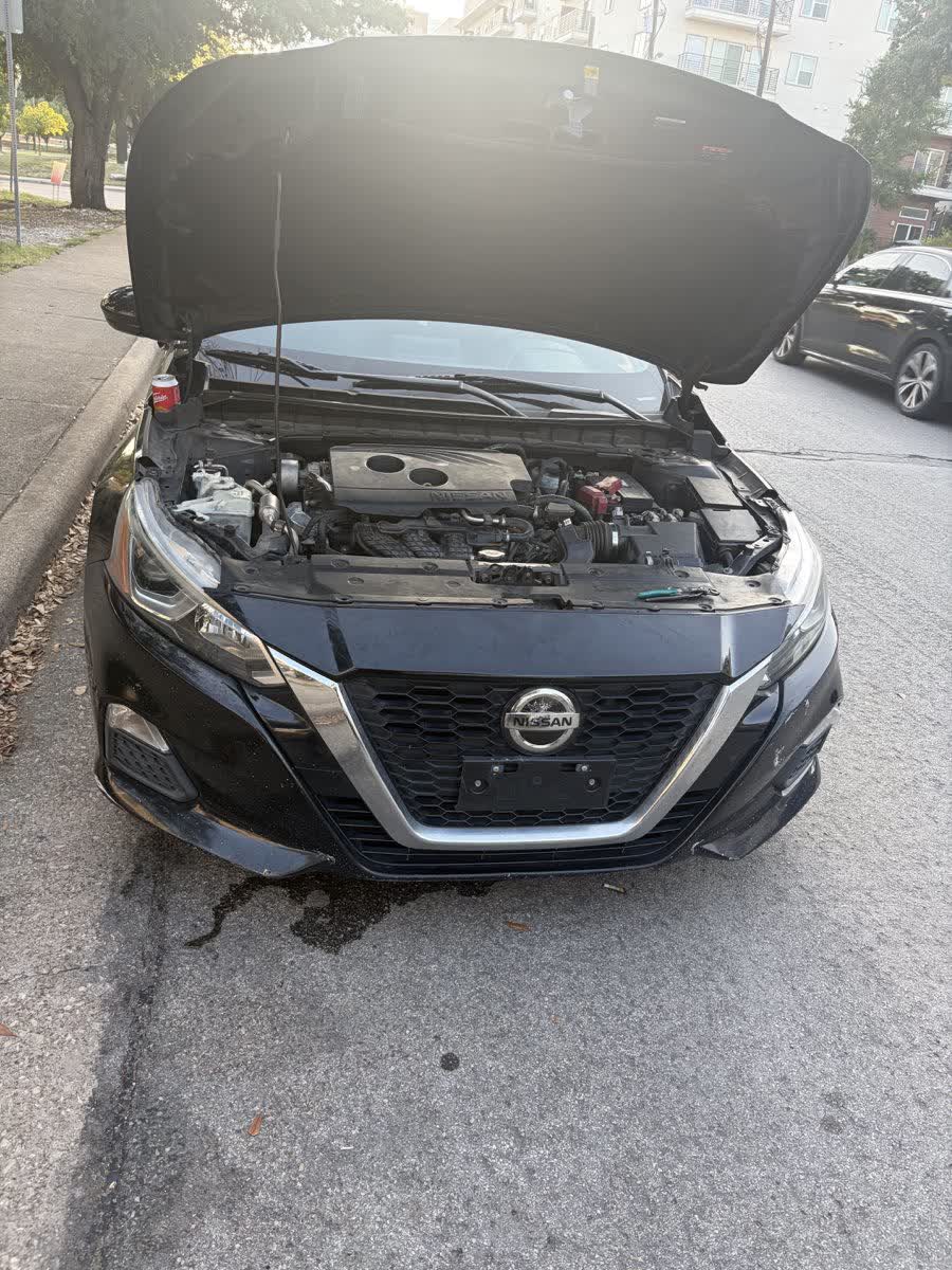 Black Nissan Altima with the hood raised during diagnostic work