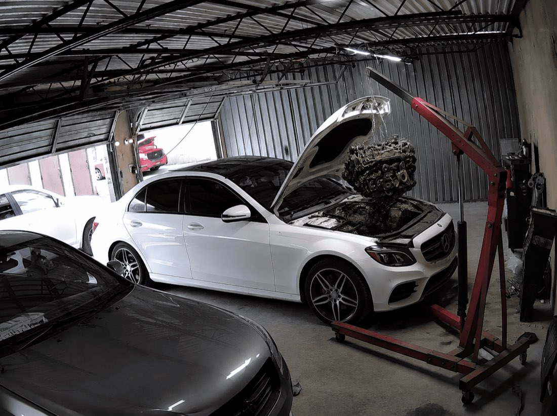 Mercedes sedan undergoing engine work inside the Ismaili Company shop